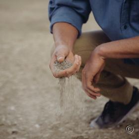 Man laat op strand zand door zijn vingers lopen